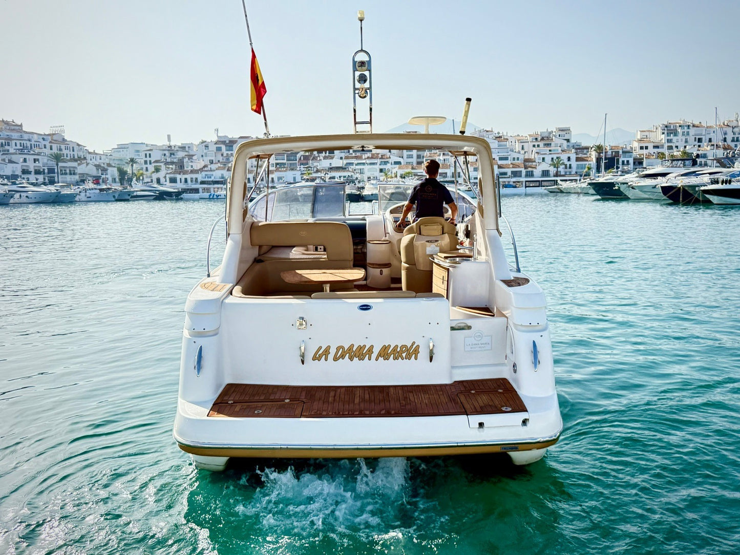 White boat with 'La Dama Azul' branding on a body of water with buildings in the background.