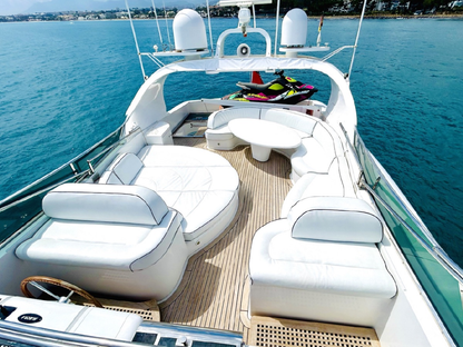 Luxury yacht with white seating area and blue water in the background